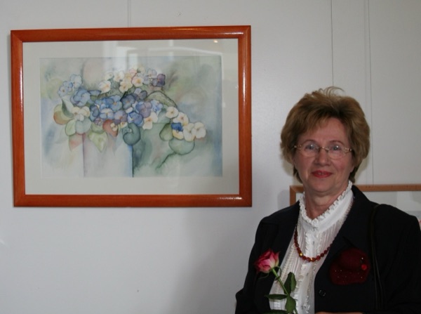 Waltraud Hoos neben einem ihrer Aquarelle bei der Ausstellung